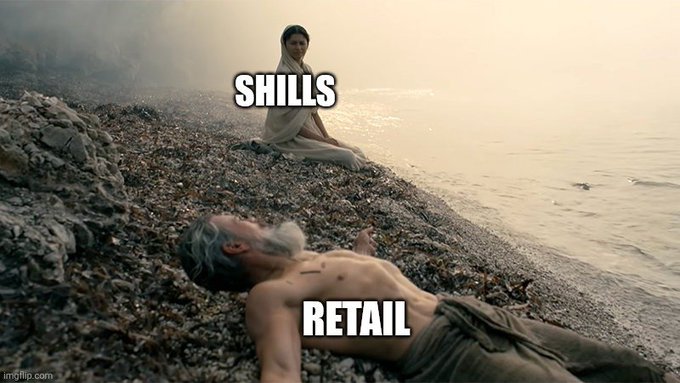 A meme using the "Starving Child vs. Old Man" template, where a strong, dignified woman labeled "SHILLS" sits composed on a riverbank while a frail, unkempt old man labeled "RETAIL" lies nearly dead on the rocks—symbolizing how crypto promoters (shills) thrive while retail investors suffer from failed investments like the fictional bag of XRP in the post.
