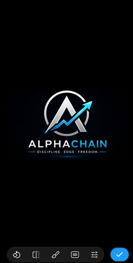 The image shows a phone screen with a logo for an online trading platform called Alpha Chain. The logo features a blue arrow pointing upwards, symbolizing growth or progress. Below the logo, there are two lines of text that read "Alpha Chain" and "discipline edo freedom". The background is black, which contrasts with the white border surrounding the logo.