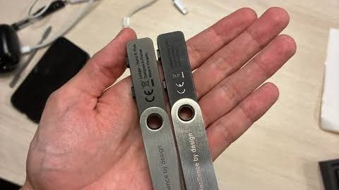 A hand holds two metal stick-on mounts labeled 'UGREEN' and 'Designed by UGREEN,' showing CE certification marks.