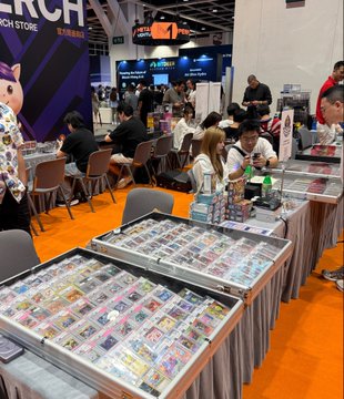 Inside the Bitcoin Asia conference venue, booths display rows of Pokémon trading cards in glass cases, blending cryptocurrency industry with collectibles culture as attendees browse the merchandise. The "BITCOIN STORE" sign is visible in the background.