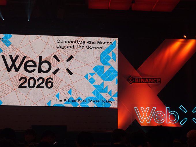 A conference stage at WebX 2026 event at The Prince Park Tower Tokyo, featuring a Binance logo, with the tagline 'Connecting the Nodes, Beyond the Screen.'