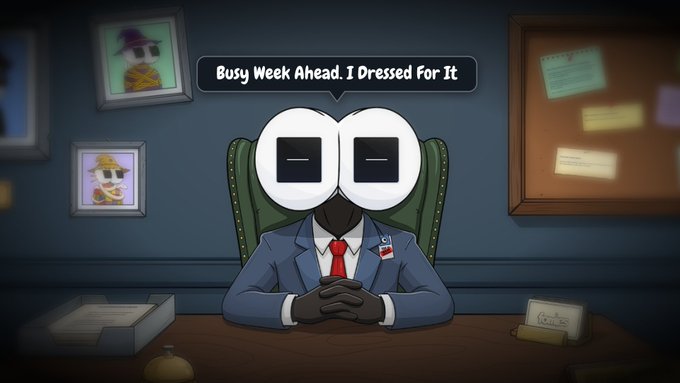 An animated character in a blue suit and red tie sits at a desk with a speech bubble saying 'Busy Week Ahead. I Dressed For It.'