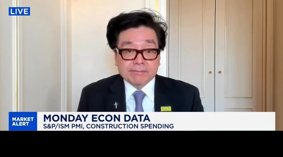 The image shows a man wearing glasses, sitting behind a desk with his hands on his lap. The text displayed on the screen reads "Live Market Alert" and "Moon Econ Data". This suggests that the image might be related to a news article or segment about cryptocurrency trading during winter months.