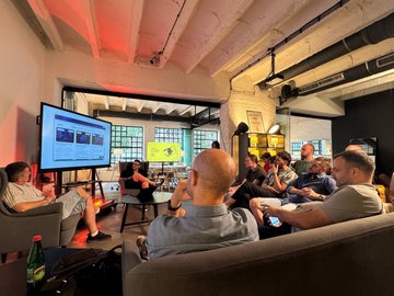 The photo shows attendees at the AI Hub Belgrade event, seated in a casual lounge area watching a presentation on a large screen that displays the Cognios platform in action. The relaxed setting complements the post's excitement about showcasing Cognios.io alongside SuperteamBLKN and startit.rs, highlighting how they transform static learning materials into interactive AI tutors with Solana technology.