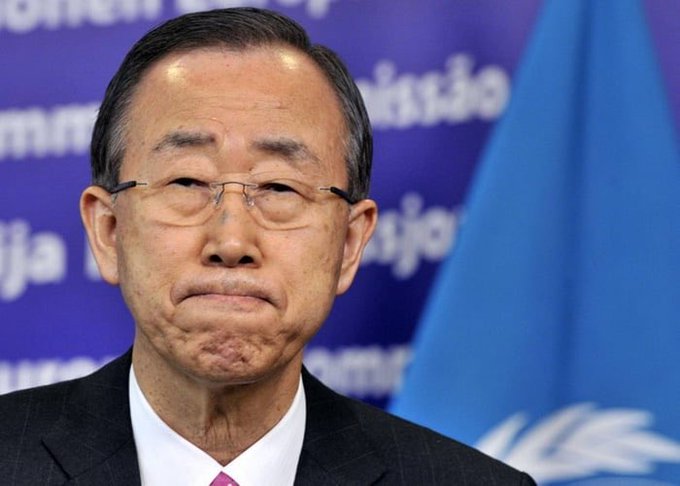 The image shows a man wearing glasses and a suit standing against a blue background with a flag behind him. The man appears to be looking down or frowning, possibly expressing concern or worry about something related to the content of the post.