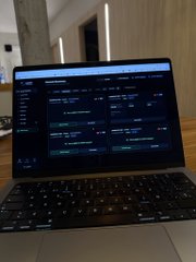 A laptop screen displays lines of code in a dark-themed text editor.