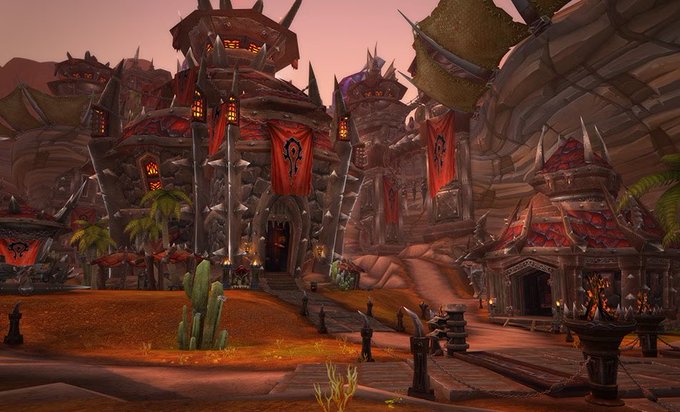 A screenshot from a video game showing a desert outpost settlement with red banners and spiked architecture, characteristic of the Orgrimmar area in World of Warcraft.