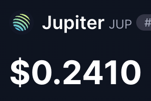 A dark interface displays the Jupiter (JUP) token logo alongside its name, a hashtag symbol, and a price of '$0.2410'.