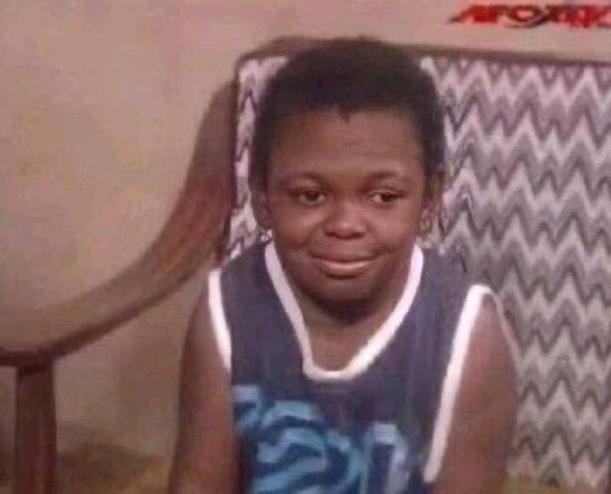 A young boy wearing a dark blue tank top with white trim sits in a chair with a zigzag-patterned cushion, displaying a wide, eager grin that perfectly captures the feeling of going "all in." The image appears to be from an old TV broadcast with "AFOXK" visible in the top right corner, and the boy's excited expression humorously matches the caption about being fully committed.