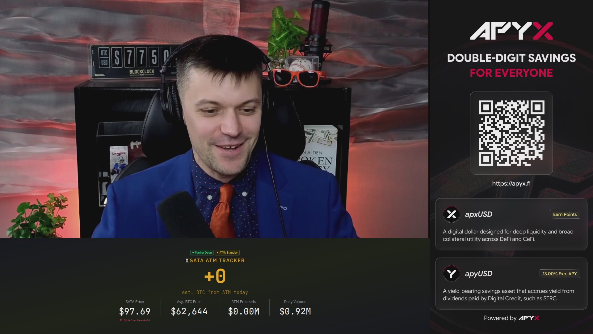 The image shows a man wearing a blue suit sitting at a desk with a computer screen displaying a message about a double-digit savings offer from Apyx. The text on the screen reads "Double-digit savings for everyone." The man appears to be smiling, indicating that he is interested in the offer or has already taken advantage of it.