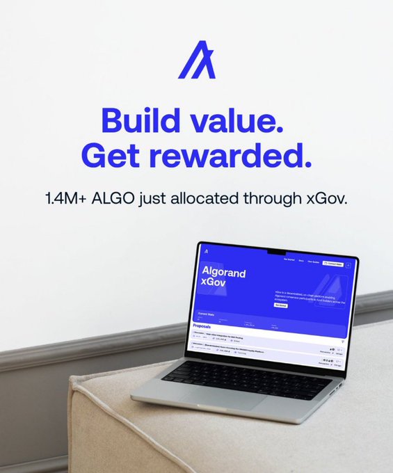 The image features a laptop computer sitting on top of a couch, with a poster or advertisement behind it. The poster promotes Algorand xGoverns, which has just been allocated funds retroactively for nine ecosystem proposals. These projects aim to add value to the community and involve the allocation of ALGO through a voting process called @Algorand xGovs. This means that the projects are being funded by the community themselves, rather than being decided in closed-room meetings or by VCs (Venture Capitalists). The poster emphasizes the importance of community involvement in decision-making processes and highlights how this funding method can lead to more efficient allocation of resources for projects that add value.
