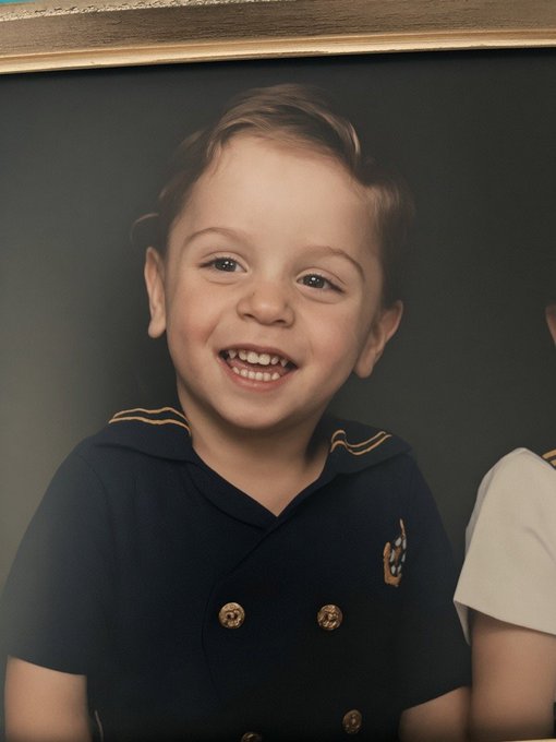 A young boy in a navy sailor-style shirt smiles brightly against a dark background, his innocent expression standing in stark contrast to the serious warning about harming users of trading platforms.