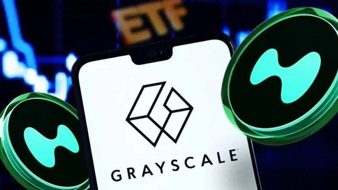 A smartphone displays the Grayscale logo and name, flanked by two green Hyperliquid ($HYPE) token graphics, against a backdrop featuring "ETF" text and a financial chart, visually representing Grayscale's new SEC filing for a Hyperliquid ETF fund that includes staking.