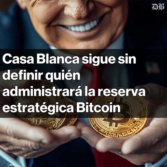 A news-style image showing a man in a suit smiling while holding two gold Bitcoin coins, with the Spanish text 'Casa Blanca sigue sin definir quién administrará la reserva estratégica Bitcoin' (The White House still hasn't defined who will manage the strategic Bitcoin reserve) and a 'DB' logo in the top right.