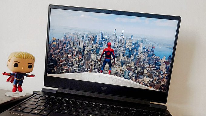A laptop displays Spider-Man perched atop a skyscraper overlooking a sweeping aerial view of New York City, while an Homelander Funko Pop figure stands beside the device, visually referencing the post's playful claim of a Spider-Man and Homelander "multiverse" crossover on the Soneium/Startale chain.