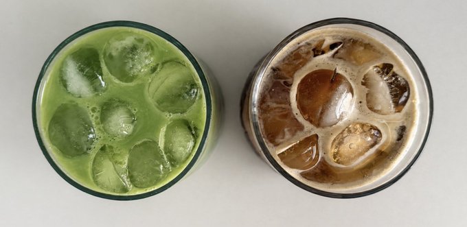 Two overpacked glasses of ice-filled drinks sit side by side—vibrant green matcha on the left and creamy iced coffee on the right—presented as two "warrior" beverage choices to pick from.