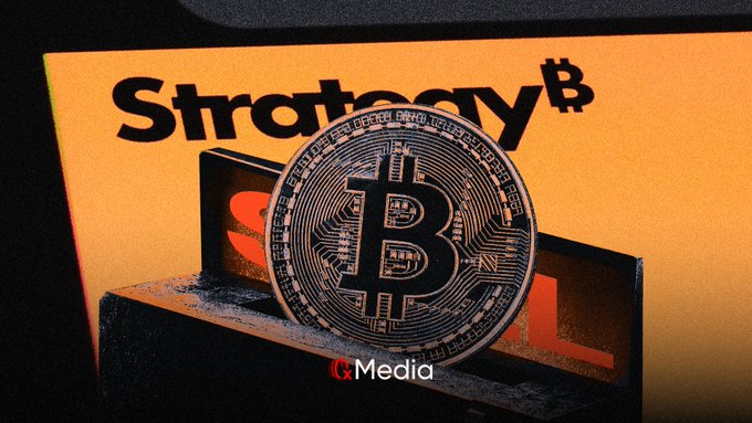Photo of a physical Bitcoin coin resting on a stack of books with 'Strategy$' visible on the cover and a red 'Media' logo at the bottom.