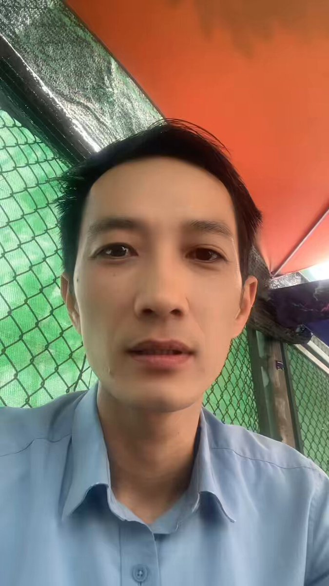 The image shows a man wearing a blue shirt, looking at the camera with an intense gaze. The photo appears to be taken from behind him or slightly above his head, giving the impression that he is peering over a fence into someone's backyard. There are no texts or other objects in the image, and there is no indication of any wallet-related activity on the Pi network.