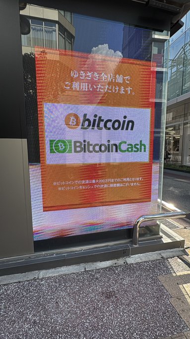 An orange digital sign outside a Yukizaki store advertises that Bitcoin and Bitcoin Cash are accepted at all locations nationwide, as a notice that the shop is now a crypto-friendly retailer. The post notes this was the fifth stop on a tour of Bitcoin-accepting shops in Japan, visited in person.
