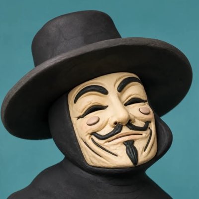 A figurine of a V for Vendetta mask and hat figure against a teal background.