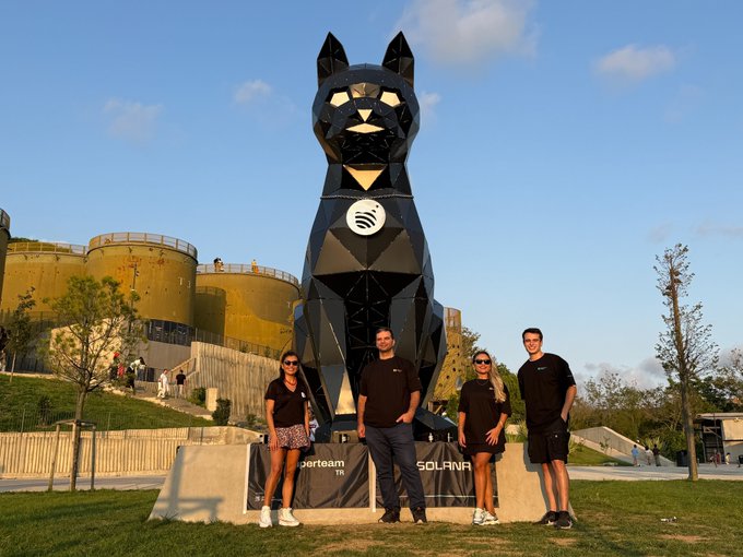 Four members of Superteam Türkiye pose proudly in front of the iconic "Catstanbul" sculpture in Istanbul, with a banner reading "SUPERTEAM TR" and "SOLANA" displayed at its base, celebrating their official adoption of the landmark cat statue as a Jupiverse icon.