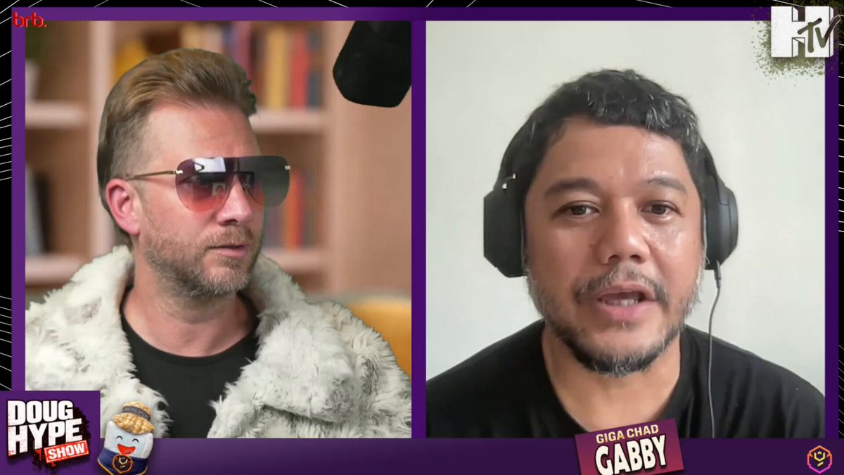The image features two men wearing sunglasses and headphones, likely participating in a video call or recording session. They are positioned behind microphones, suggesting that they might be discussing something related to their content creation process for vibecoded games. The background of the image shows a gray wall with a poster featuring the words "Ygg Play" and "Gabby Dizon". This could indicate that the two men are involved in the video game industry or have recently been featured on a platform like Ygg Play.