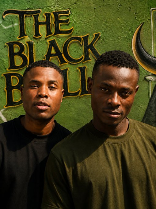 Two young men pose in front of a green wall with "THE BLACK BULL" painted on it, with one wearing a black shirt and the other in an olive green shirt. The post celebrates their influence in CT (cryptocurrency/culture) and references the "TBH" ticker associated with The Black Bull.