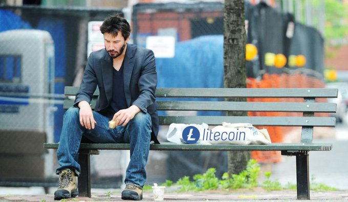 A man sits alone on a park bench with a bag labeled "litecoin" beside him. The image is a meme related to cryptocurrency.