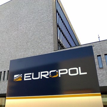 An exterior shot of a modern building displaying a large 'EUROPOL' sign with its logo featuring the European stars.
