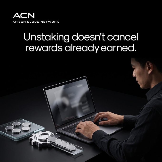 The image shows a man working on a laptop with a blurred lock icon on the screen, alongside an acrylic display of metallic tokens and gears, accompanied by the ACN (AITECH CLOUD NETWORK) logo and the text "Unstaking doesn't cancel rewards already earned." The locks, tokens, and gears visually reinforce the post's message about crypto staking—illustrating that unstaking your tokens (represented by the locks) doesn't void your existing rewards (the coins), which remain secured and yours to keep.