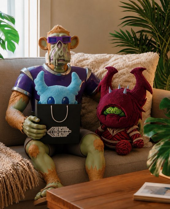 The image features a man sitting on a couch with two stuffed animals, including a green monster figure and a red dragon plushie. The man is wearing sunglasses and holding a black shopping bag. A book can be seen placed next to him on the couch. The background of the image shows a window overlooking some plants outside.

The post includes text that reads "GM Secured two @OthersideMeta KODA @phygitals yesterday! One for my daughter to rock and one to stock". This suggests that the man might be interested in collecting unique or unusual items, such as monster figures or other collectibles. The presence of a book on the couch also indicates that he enjoys reading or learning about various topics related to his interests.