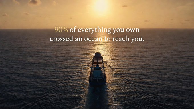 A cinematic shot of a cargo ship sailing toward the sun on a calm ocean, overlaid with the text '90% of everything you own crossed an ocean to reach you.'
