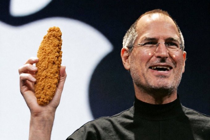 Photo of Steve Jobs holding up a fried chicken drumstick instead of a phone, set against an Apple logo background.