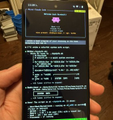 A person holds a smartphone displaying a dark-themed app interface with text and purple icons.