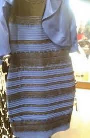A mannequin displays a fitted, sleeveless dress featuring horizontal stripes in brown and white tones, paired with a light blue cropped jacket or shrug draped over the shoulders. The outfit appears to be styled in a boutique or retail setting.