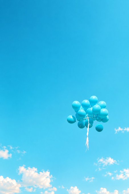 A cluster of light blue balloons floats against a clear, bright blue sky with a few wispy clouds near the horizon.