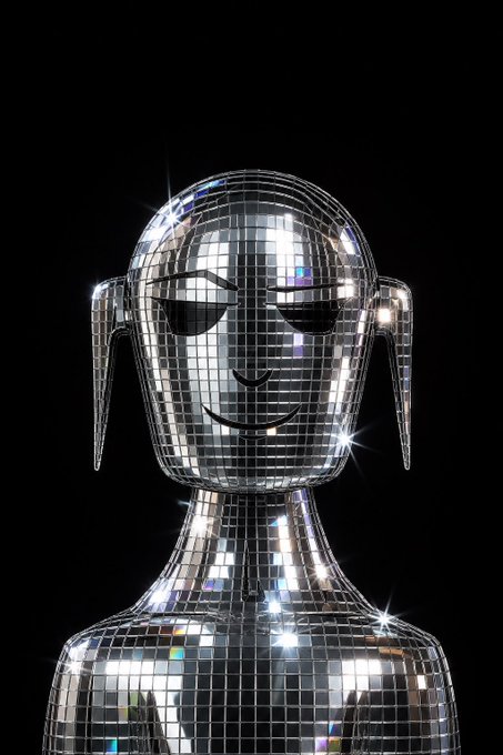 A disco ball sculpture of a humanoid figure with closed eyes and a subtle smile, sparkling against a black background, symbolizes the creative, building mindset of the post about stacking, creating, and shipping new ideas.