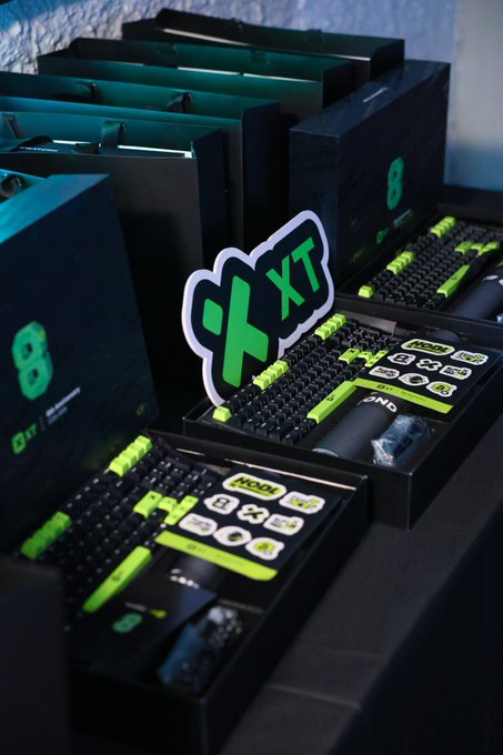 Black boxes with bright green mechanical keyboards inside are displayed, with a green 'XT' sticker attached to one box and '8' visible on the packaging.