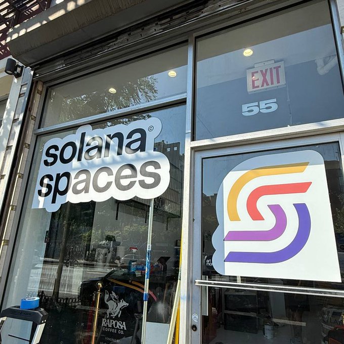 The image shows a storefront with two signs displayed, one of which reads "SOLANA SPACES", indicating that the store specializes in selling various items for sale. The other sign displays an exit number, likely 55 or 56, suggesting that this is a location where customers can easily access the store and its offerings.

In front of the store, there are two cars parked - one black car on the left side and another white car on the right side. A person can be seen standing near the cars, possibly waiting to enter the store or just passing by.