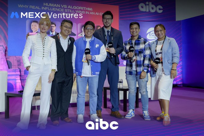 The image features a group of six people standing together for a photo at an event. They are all smiling and posing with their cameras, likely capturing memories from the panel discussion they attended. The event appears to be related to AI, blockchain, Web3, or emerging technologies, as suggested by the title "Human vs Algorithm: Why Real Influence Still Wins in an AI-Driven Market".
