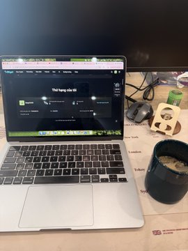 A photo of a MacBook laptop on a desk displaying a presentation, with a panda-themed mug and coffee cup beside it.