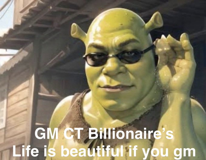 A person dressed as the character Shrek wearing glasses and adjusting them, with text overlay reading 'GM CT Billionaire's Life is beautiful if you gm'.