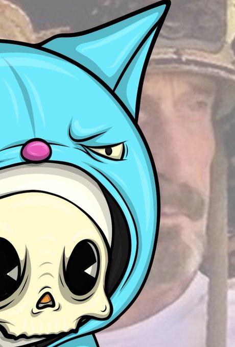 A cartoon-style character wearing a blue hood with cat ears, featuring a purple button on top and a large skull face on the front, set against a blurred background.