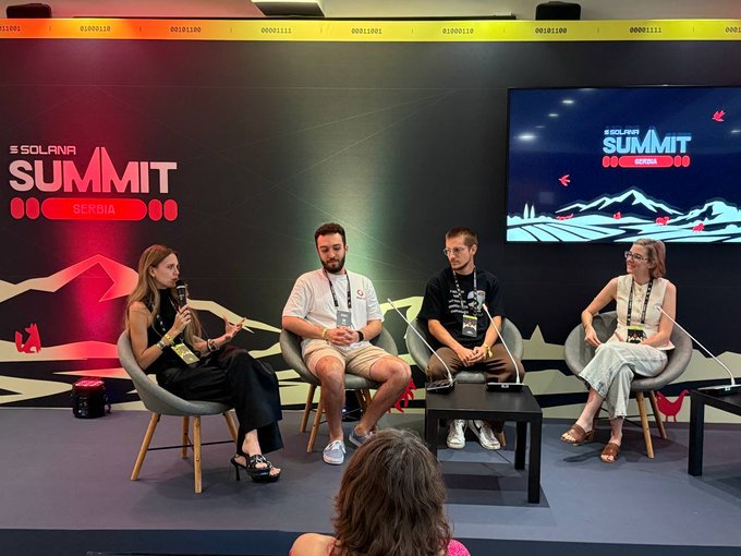 A panel discussion at the Solana Summit Serbia featuring four speakers seated on stage with microphones, with 'SOLANA SUMMIT SERBIA' branding displayed on the backdrop and screen.