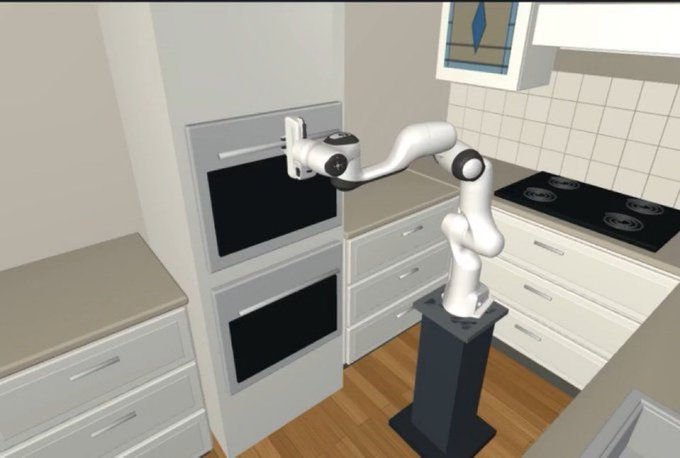 A robotic arm is mounted on a pedestal in a kitchen, positioned in front of a double wall oven with its end effector pointed toward the oven door handle.