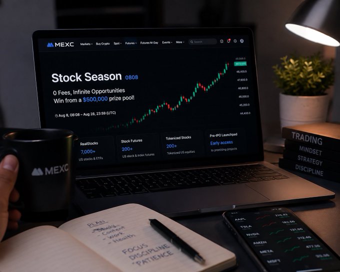 A laptop displays the MEXC "Stock Season 0808" event page highlighting "0 Fees, Infinite Opportunities" with a $500,000 prize pool and showing benefits like 7,000+ RealStocks, 200+ Stock Futures, and 200+ Tokenized Stocks, alongside a notebook listing "FOCUS DISCIPLINE PATIENCE," a MEXC mug, and a phone showing stock tickers like AAPL, TSLA, and NVDA — visually reinforcing the post's message that the real value for traders lies in MEXC's zero-fee offerings rather than the headline prize.