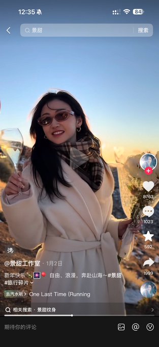 A short video from Douyin shows a smiling woman in sunglasses and a beige coat holding a glass, with a search query at the top reading "景甜" (Jing Tian).