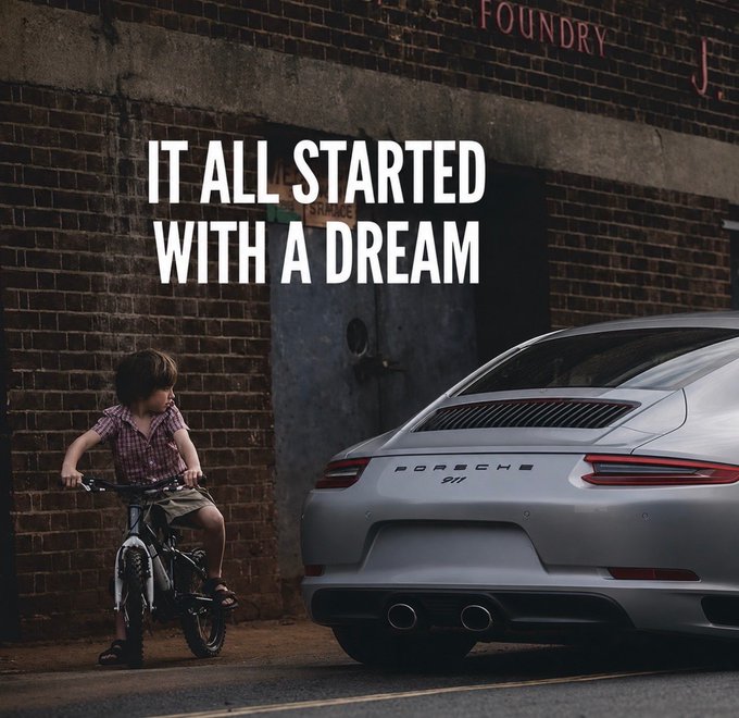 An advertisement displays a young boy on a bicycle next to a silver Porsche 911 parked by a brick wall, with the bold text overlay reading 'IT ALL STARTED WITH A DREAM' and 'PORSCHE 911' visible on the car.