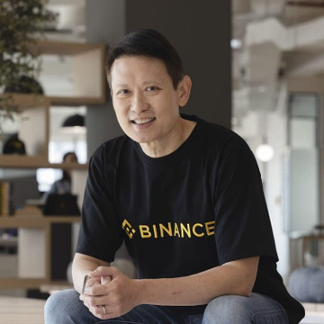 A man wearing a black Binance t-shirt smiles while seated indoors, appearing to be Richard Teng, the Binance CEO mentioned in the post about their collaboration with India's NCB to dismantle a darknet drug ring via on-chain transaction tracing.
