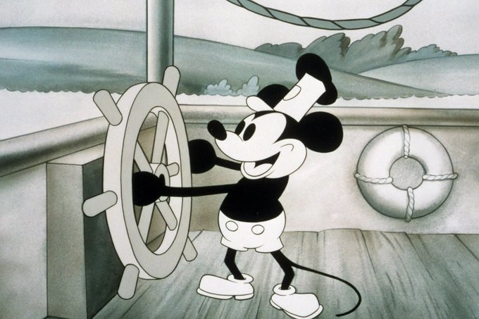 Mickey Mouse, wearing his classic white shorts, gloves, and cap, smiles while steering a ship’s wheel aboard a boat. The image evokes the idea of taking an existing character or NFT and creatively expanding it into a new story or intellectual property.